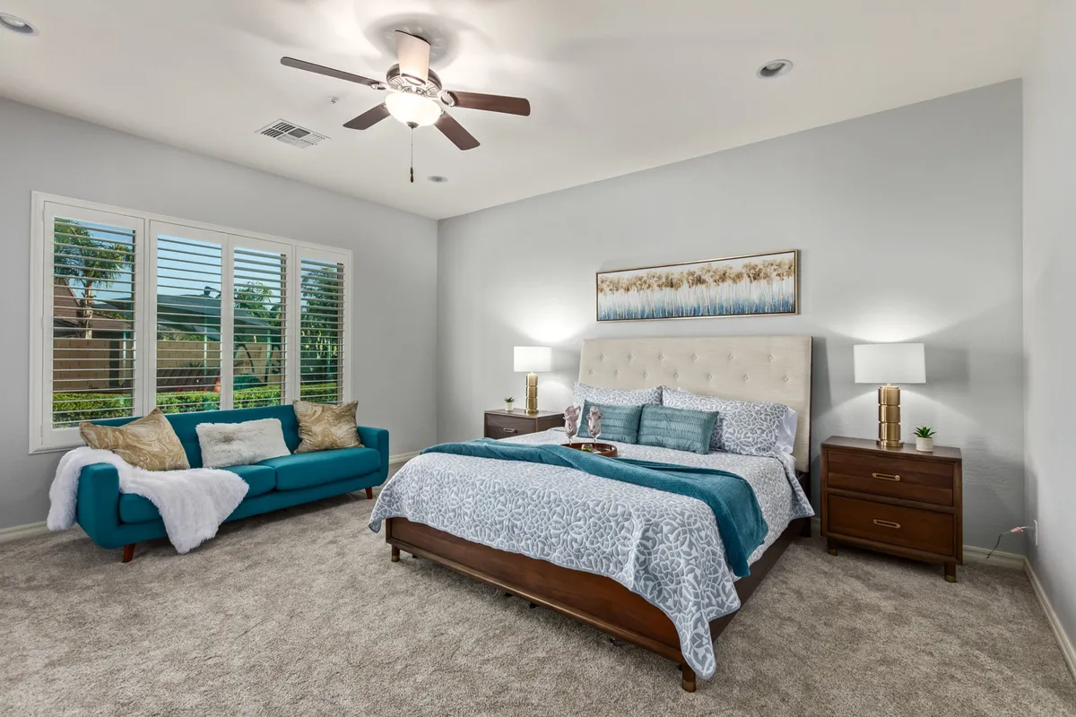 This interior shot showcases a calm, elegantly styled bedroom with a bed, sofa, tasteful wall art, and soft lighting from table lamps. The atmosphere is cozy and restful—ideal for quiet retreats and recharging after active or productive days.